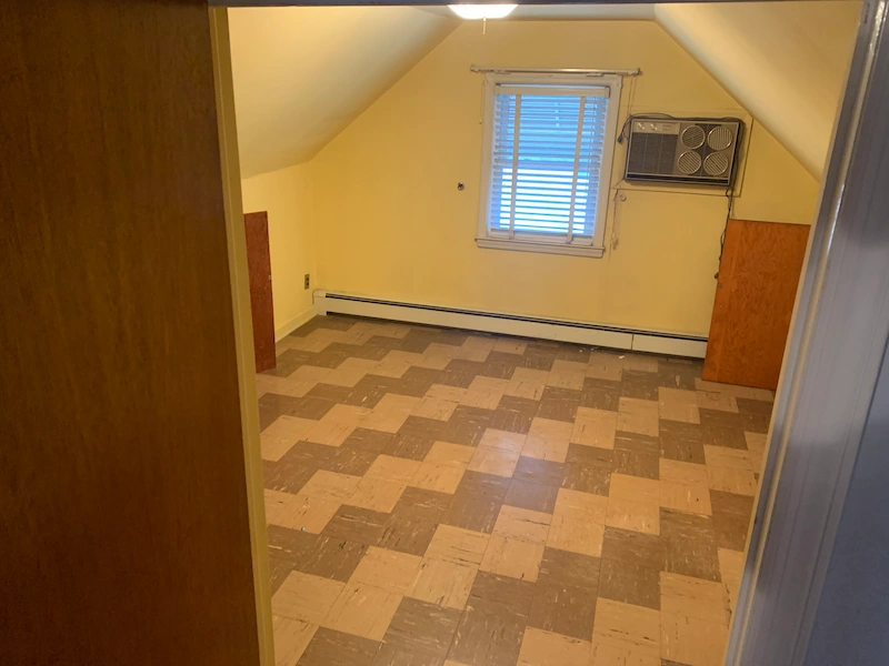 The same Glen Ridge, North Jersey attic space completely cleared of all clutter and debris, showing a clean checkered floor and empty room after professional junk removal.
