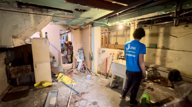 Junk Doctors team member clearing out construction waste and old building materials during a residential basement remodeling project.