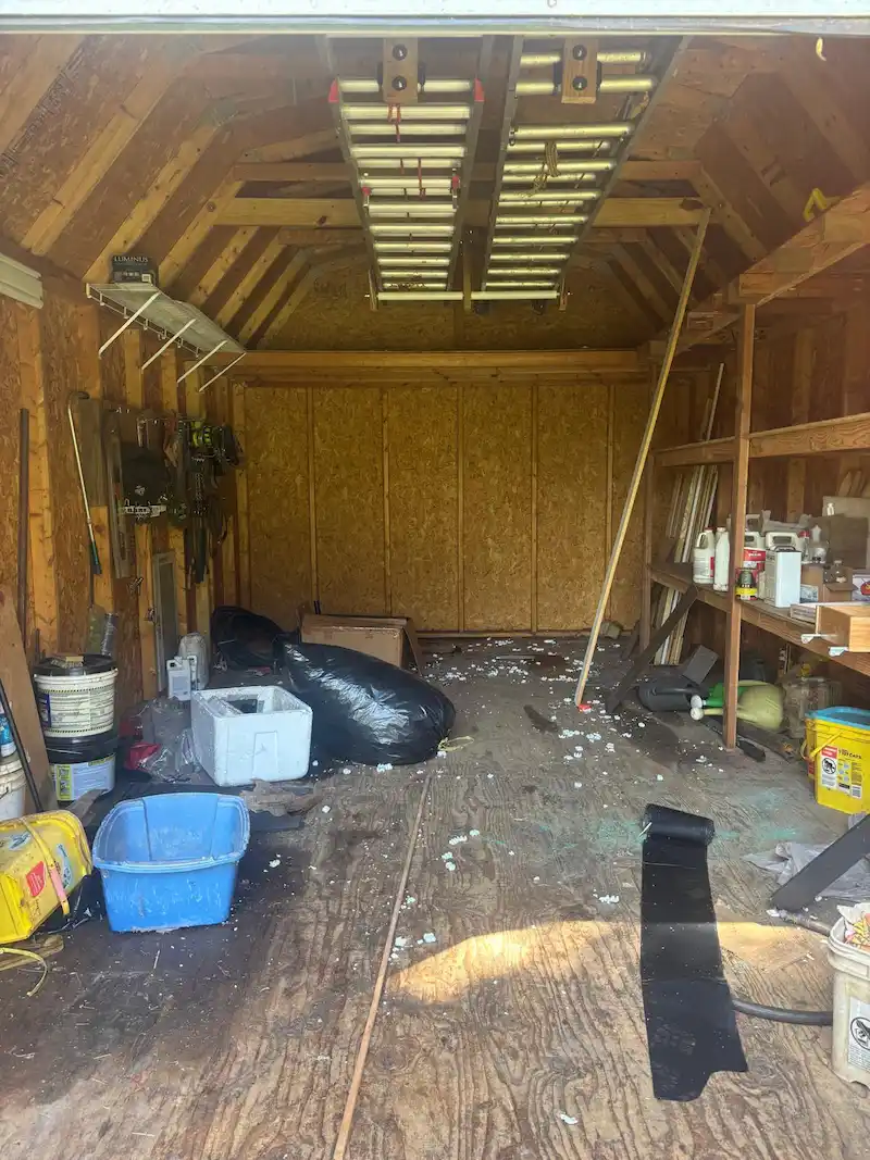 Interior of a cluttered Edison, New Jersey storage shed filled with ladders and debris before being hauled away by JunkDoctors.
