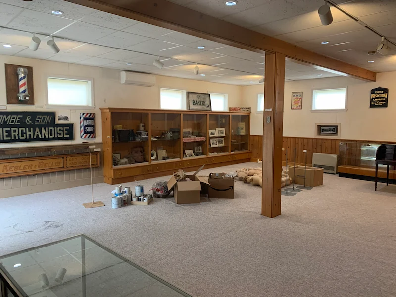 A library basement space with old, worn carpet before removal by JunkDoctors in Edison, New Jersey.