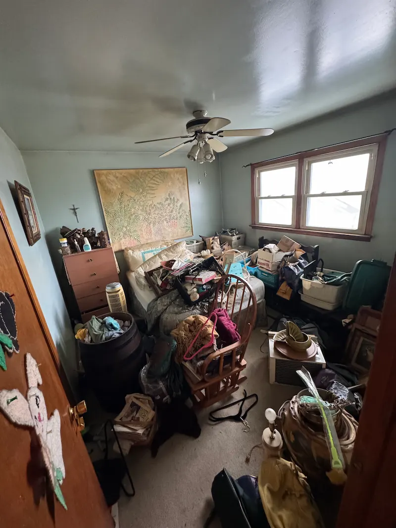 A heavy residential junk accumulation situation in a Montclair, New Jersey bedroom before JunkDoctors performed a full estate cleanout.