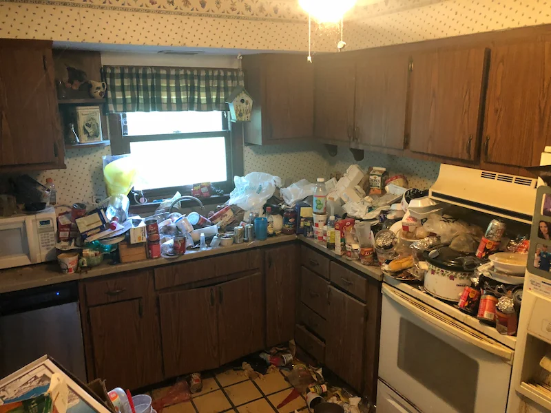 Severe hoarding conditions in a Willingboro, New Jersey kitchen featuring heavy accumulation of food debris, trash, and items covering all surfaces before a JunkDoctors cleanout.