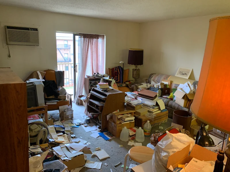 Severe apartment hoarding situation in Newton, New Jersey with furniture, papers, and household debris before JunkDoctors performed a full cleanout.