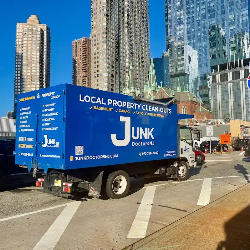 Junk Doctors NJ professional hauling truck driving to a commercial property cleanout in a busy northern new jersey area.