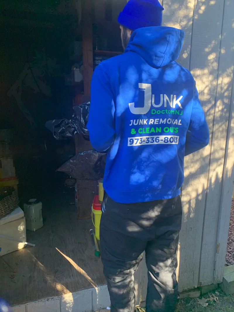 A JunkDoctors NJ team member in uniform preparing to clear out a residential storage shed in New Jersey.