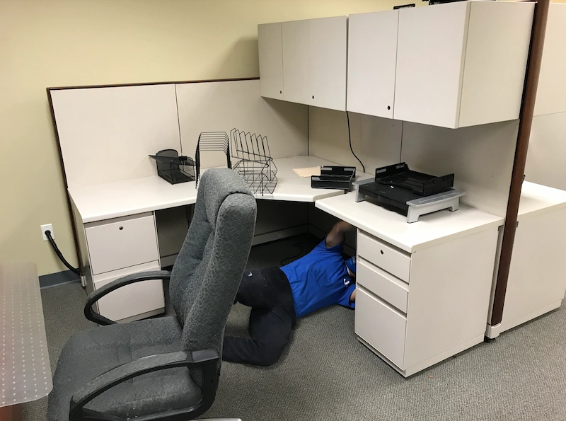 A JunkDoctors NJ team member dismantling a modular office cubicle workstation during a commercial office cleanout.