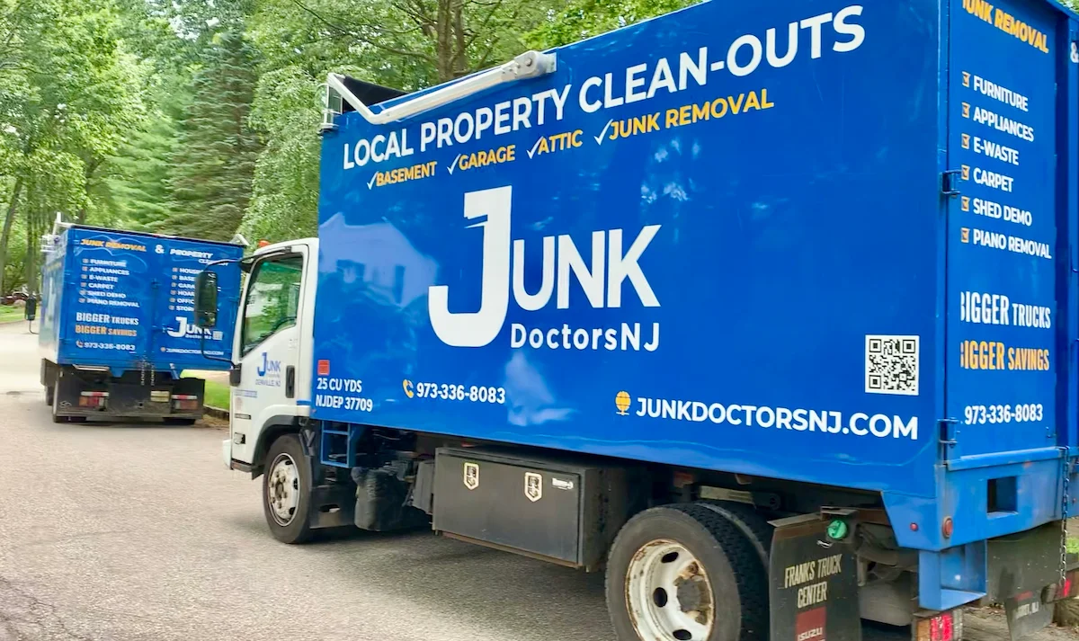 Two Junk Doctors NJ professional hauling trucks on-site in a residential North Jersey neighborhood, featuring specialized piano removal and heavy item hauling services.