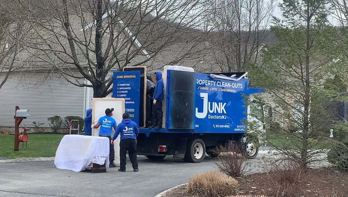 JunkDoctors team member loading a heavy mattress and box spring into a JunkDoctors removal truck.