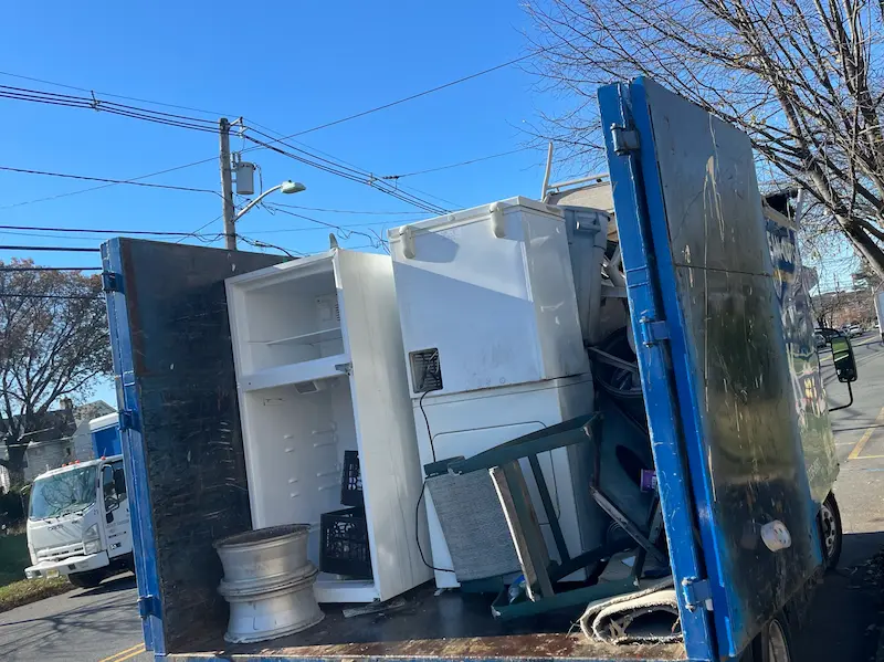 An old refrigerator being hauled away in a Junk Doctors NJ truck for professional appliance removal and eco-friendly disposal.