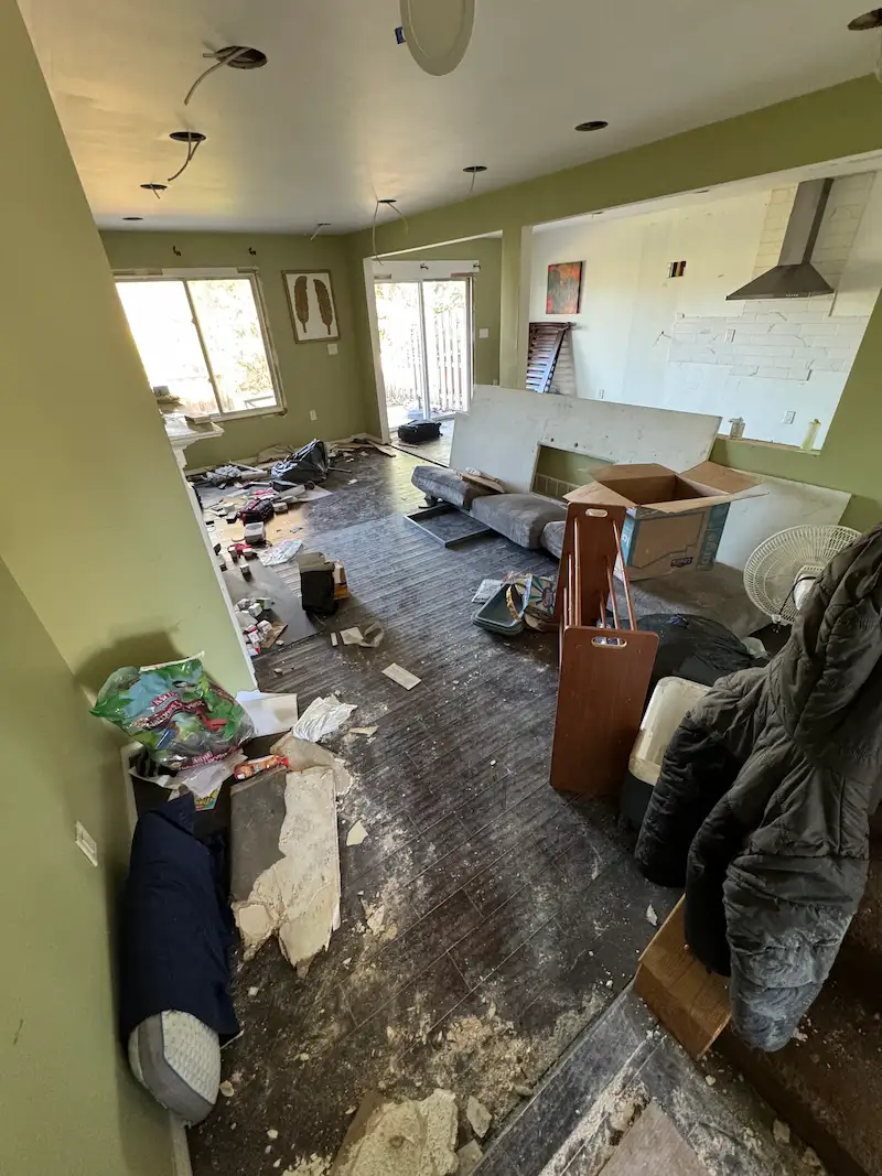 Before image of a living space cluttered with renovation materials and waste before a professional debris removal service in New Jersey.