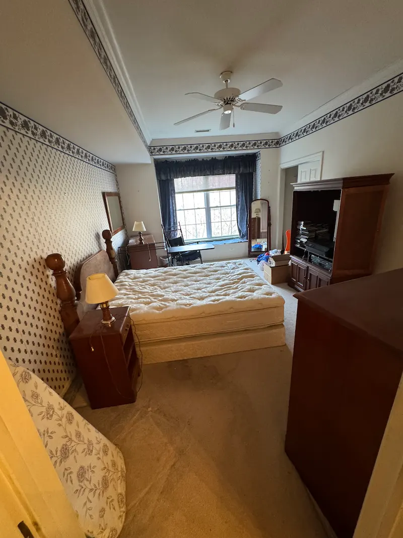 Cluttered residential bedroom before a professional local cleanout in New Jersey.