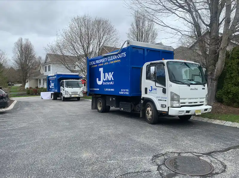 Two 25-yard JunkDoctors trucks parked in an upscale New Jersey neighborhood for a full residential property cleanout.