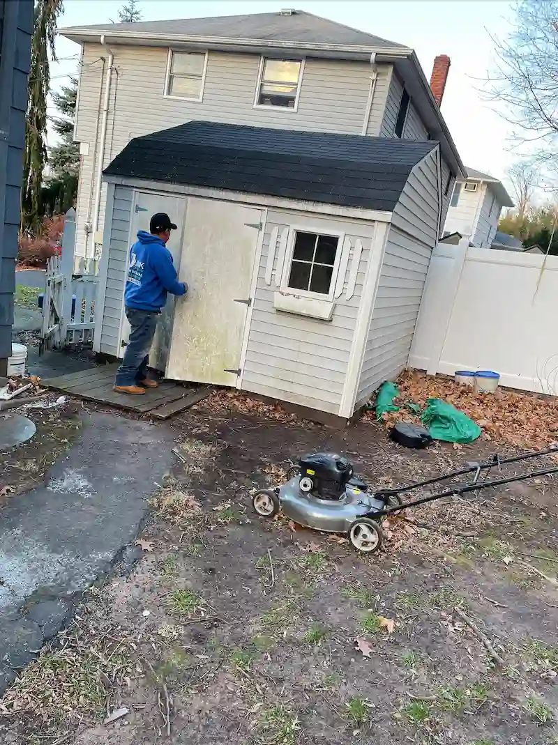 Professional JunkDoctors crew member preparing for a backyard shed demolition and removal in New Jersey.