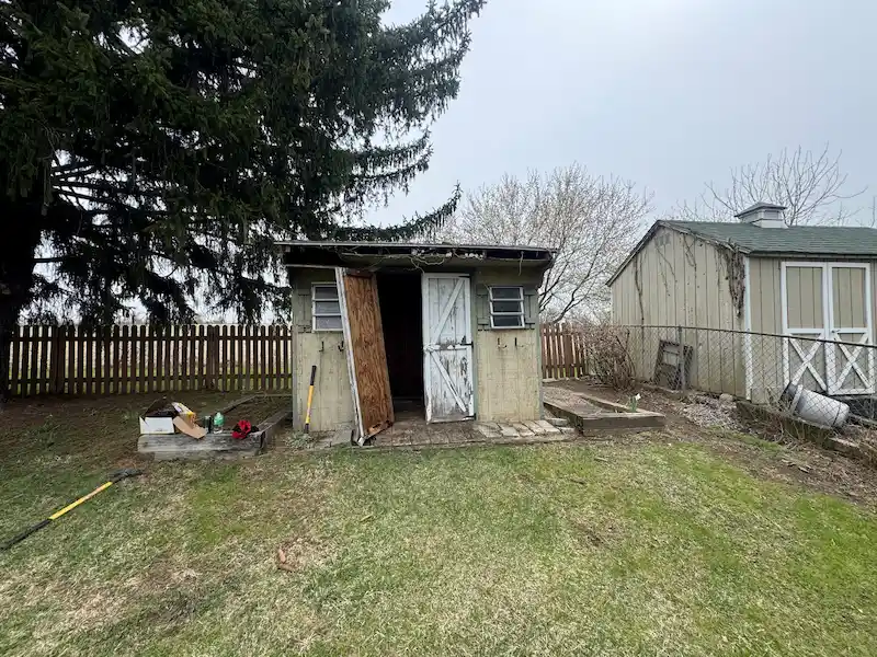 An old, decaying wooden backyard shed in North Jersey before being demolished and removed by JunkDoctors.