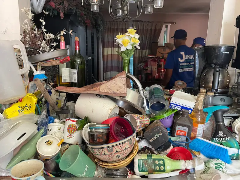JunkDoctors crew member working inside a cluttered cleanout space.
